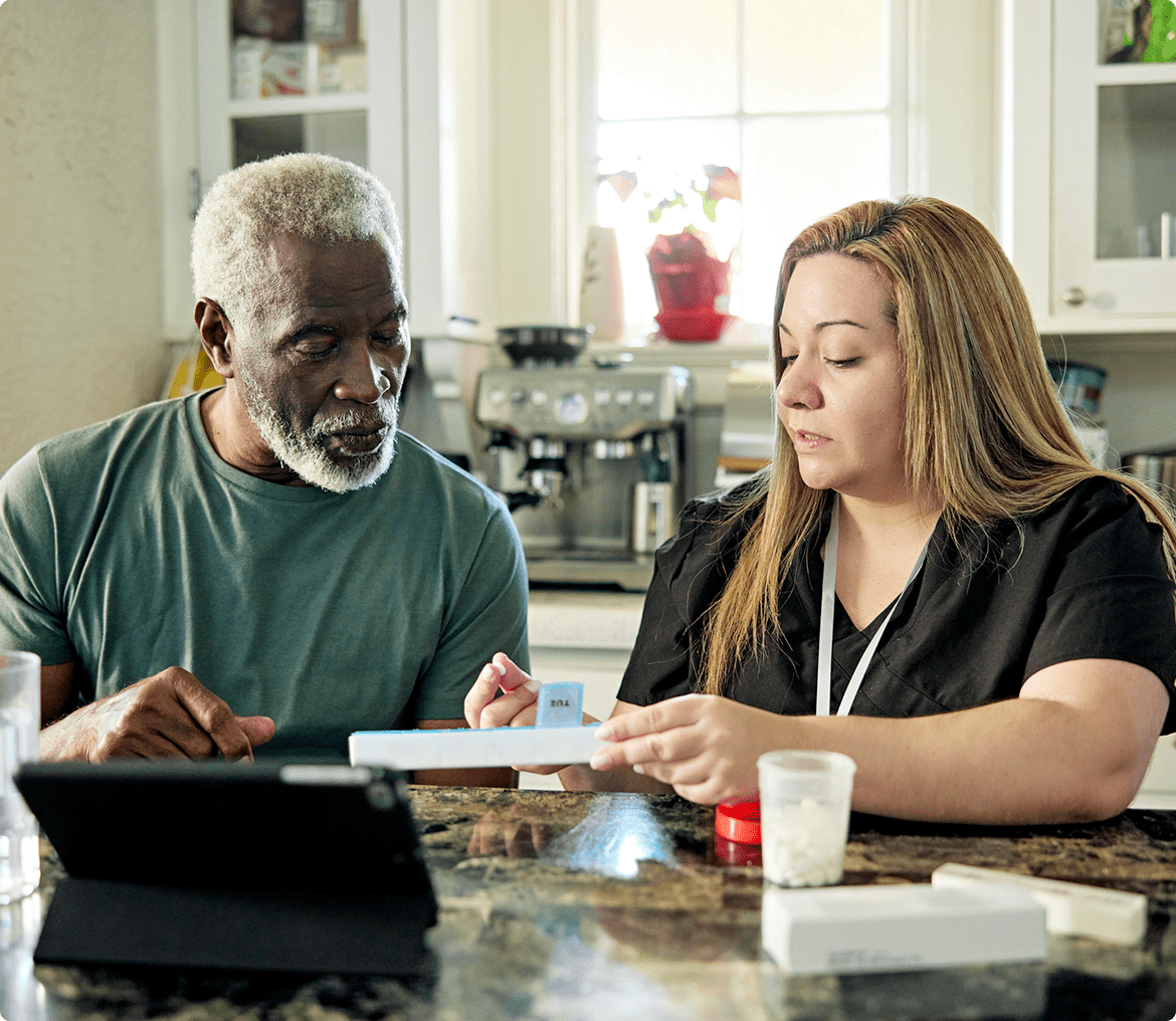 Elderly man and caregiver reviewing documents